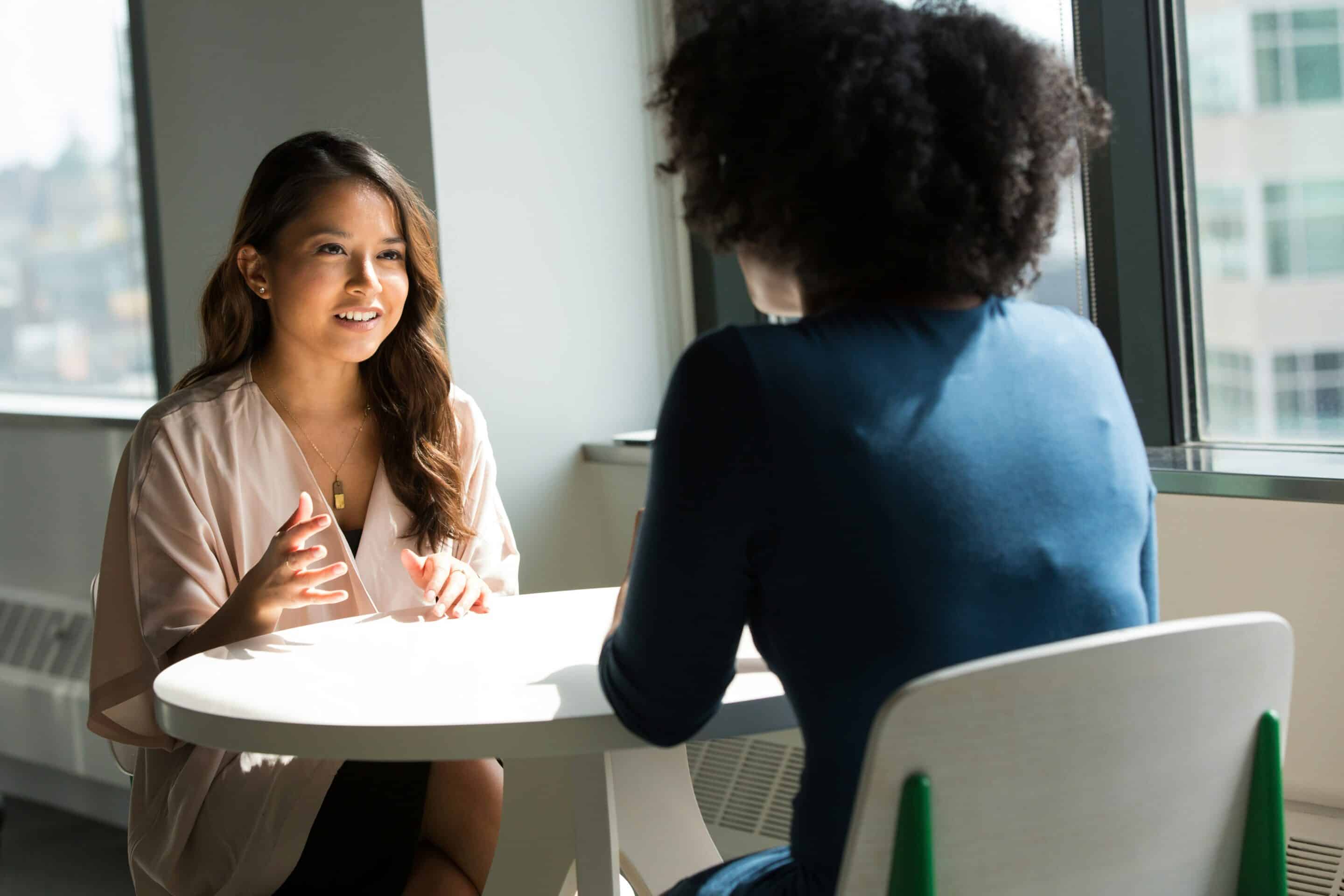 Due persone sedute una di fronte all’altra durante una conversazione, immagine rappresentativa di un incontro di psicoterapia.
