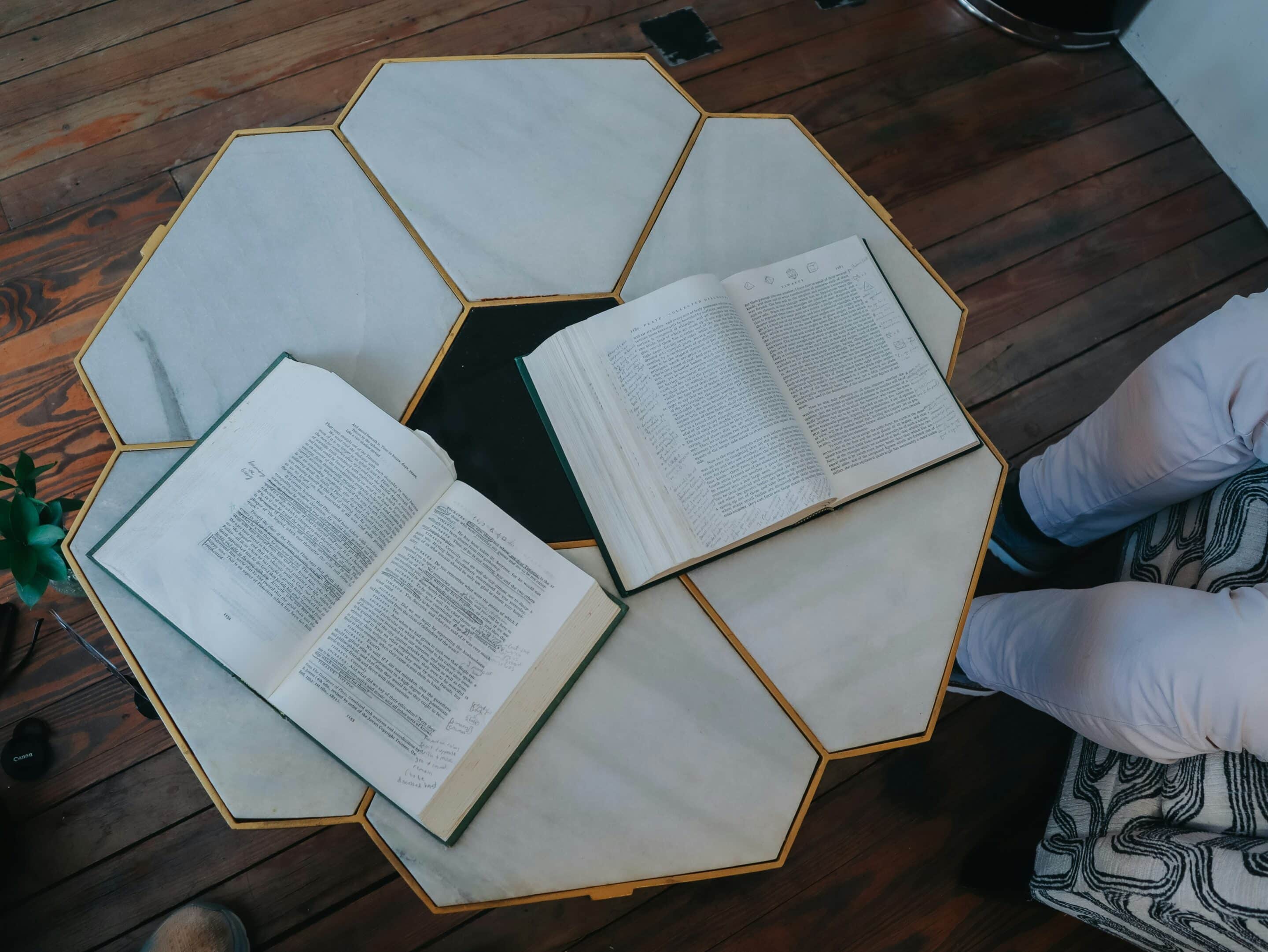 Due libri aperti su un tavolino, immagine che richiama un incontro di lettura condivisa.