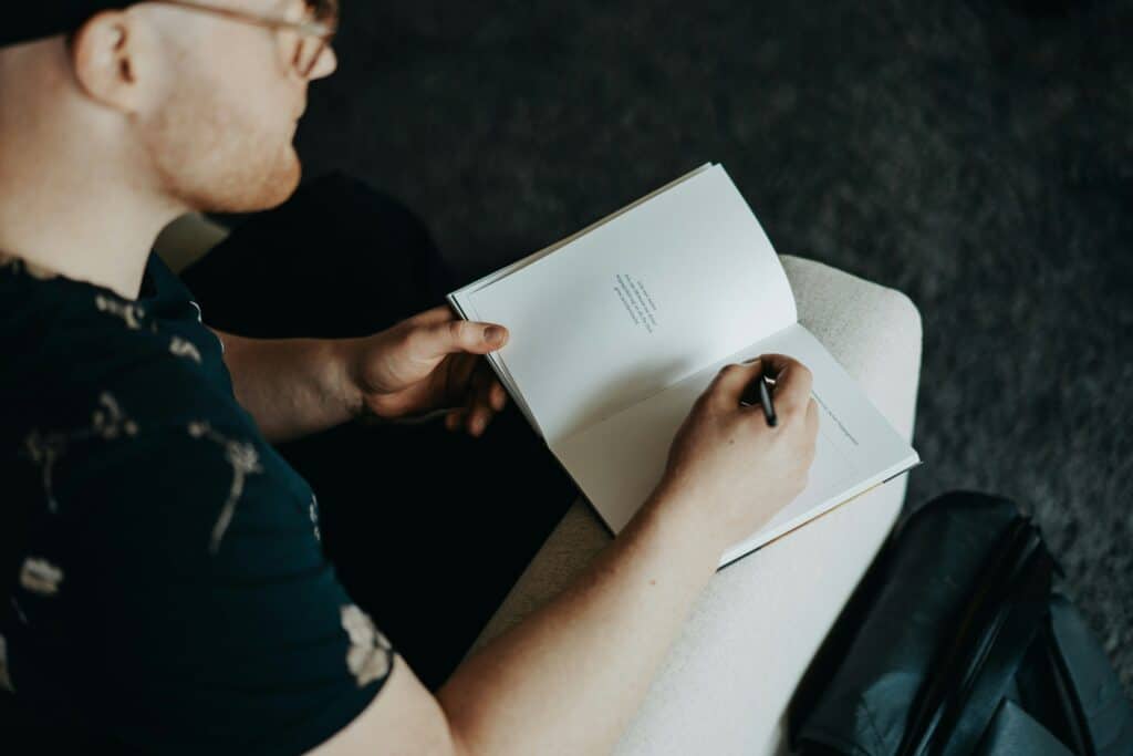 Una persona scrive su un quaderno in un momento di riflessione, immagine legata all’autocompassione e alla gentilezza verso se stessi.