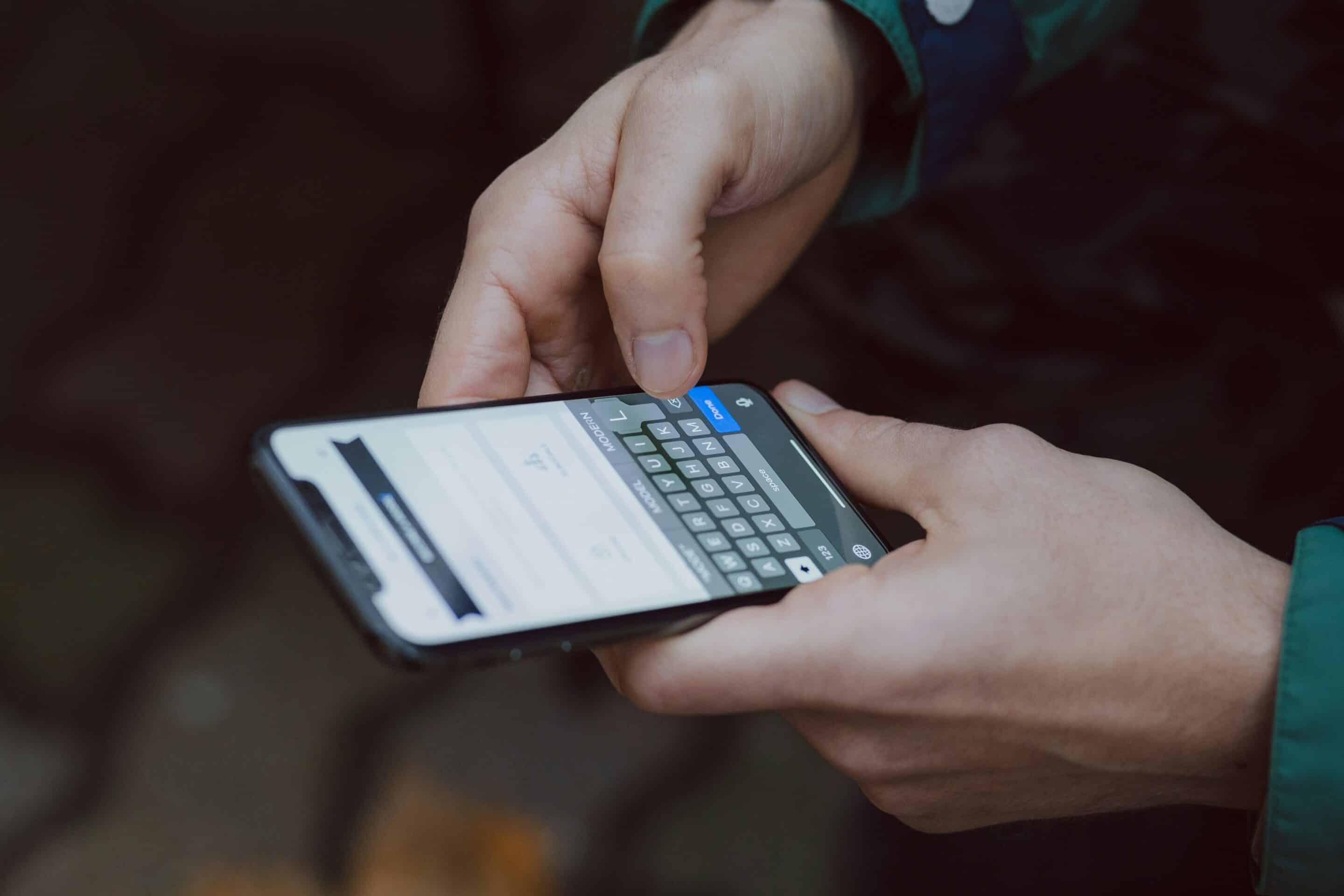 Una persona tiene il telefono tra le mani e sta scrivendo un messaggio.