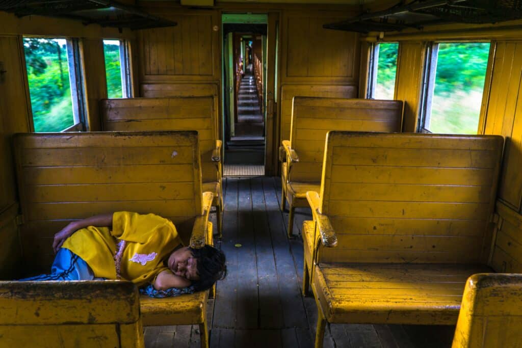 Persona addormentata su un treno durante il giorno, immagine legata alla sonnolenza diurna.