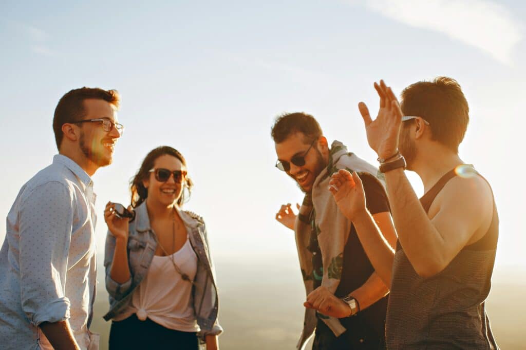 Gruppo di amici che ride insieme durante un momento conviviale, esempio di come un momento positivo non escluda la presenza di sofferenza psicologica.