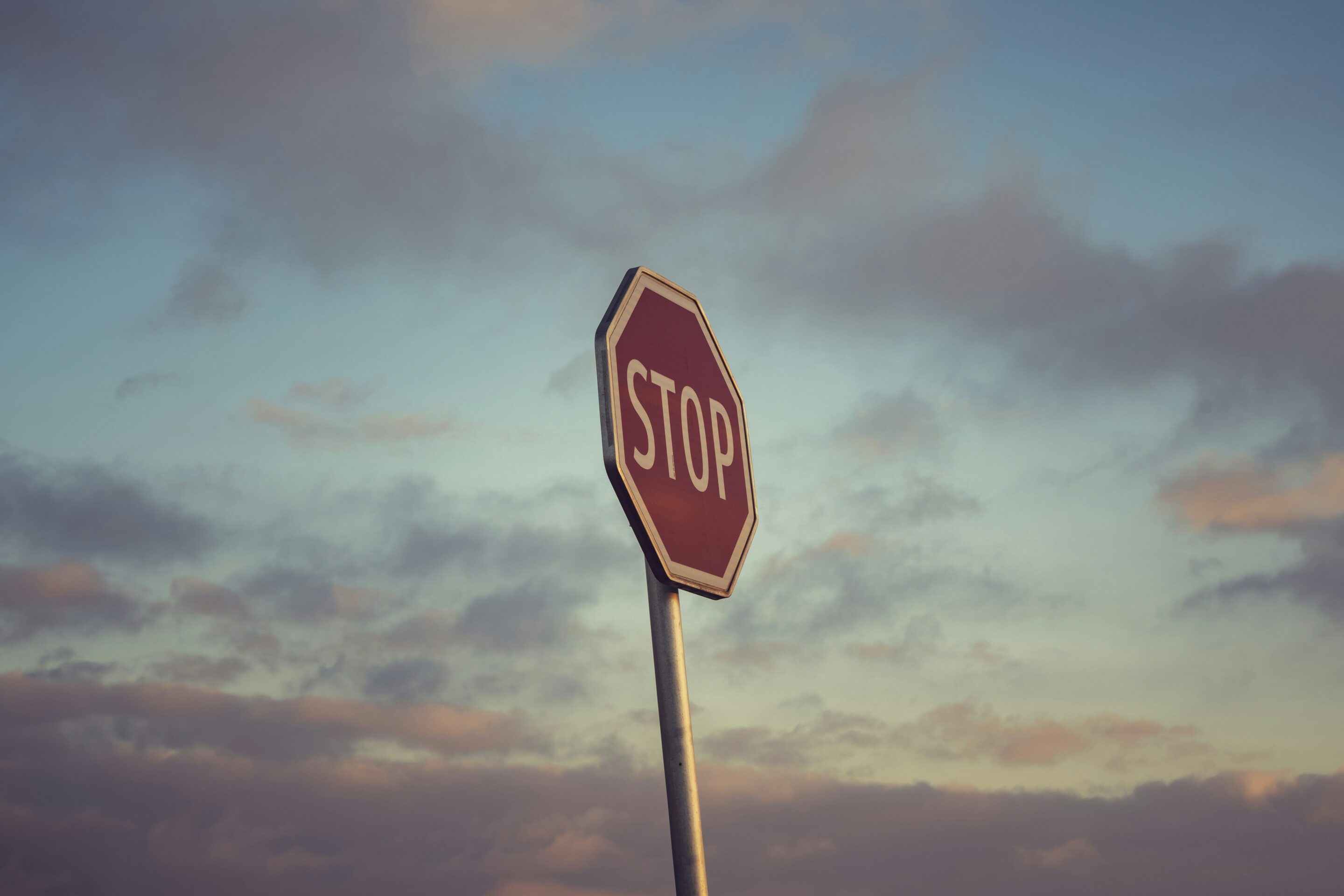 Cartello STOP contro il cielo, immagine simbolica del mettere confini e imparare a dire no nelle relazioni.