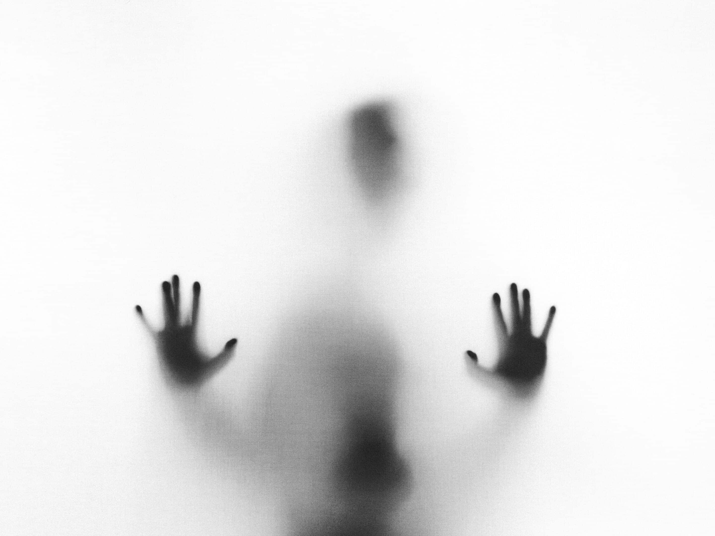 Sagoma sfocata di una persona dietro un vetro opaco, simbolo della paura e delle fobie affrontate attraverso la terapia dell'esposizione.