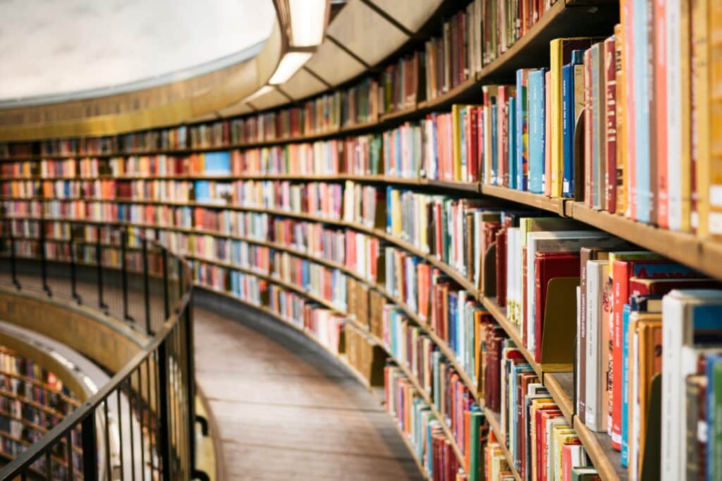 Scaffali curvi pieni di libri all'interno di una biblioteca, immagine che accompagna l'incontro sulle psicoterapie costruttiviste a Saronno.